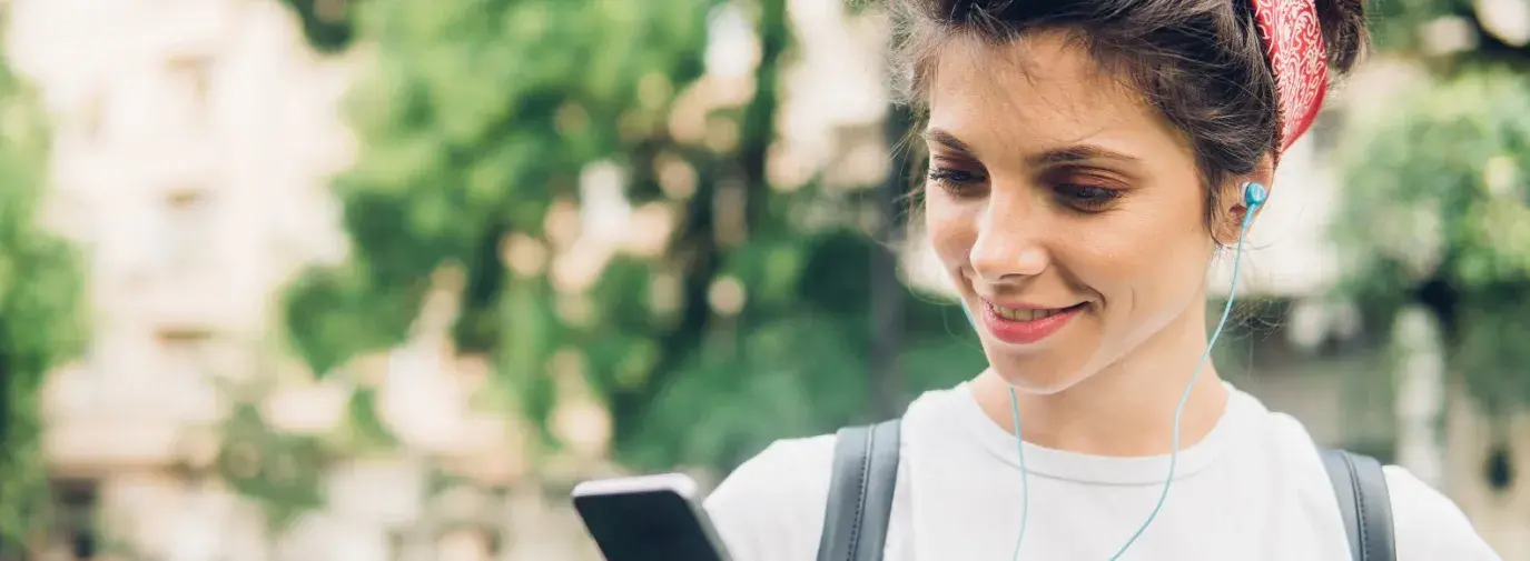 girl standing outside listening to a podcast